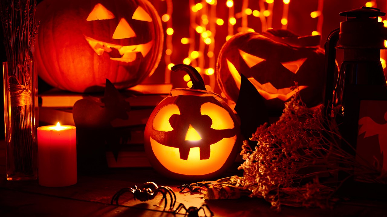 A group of carved pumpkins with a candle inside.